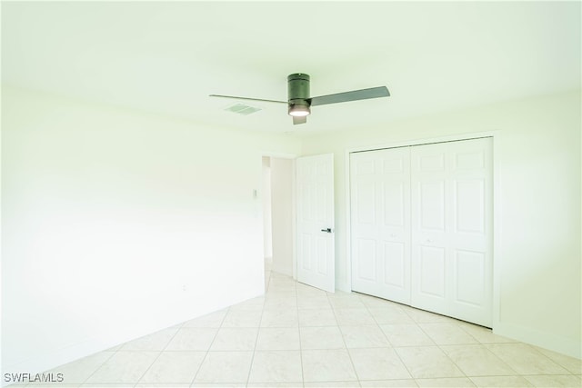 unfurnished bedroom featuring ceiling fan, a closet, and light tile patterned floors