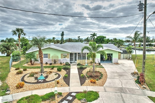 single story home featuring a water view and a front lawn