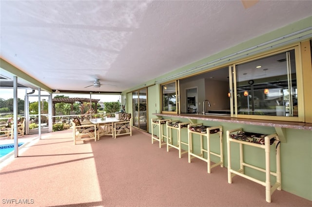 sunroom / solarium featuring ceiling fan and sink