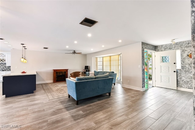 living room with ceiling fan and light hardwood / wood-style floors