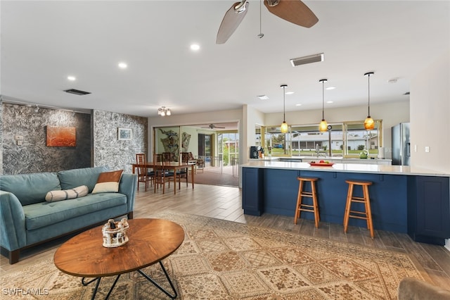 living room featuring ceiling fan and light hardwood / wood-style flooring