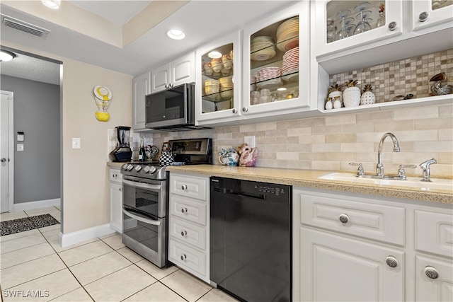 kitchen with white cabinetry, sink, decorative backsplash, light tile patterned flooring, and appliances with stainless steel finishes