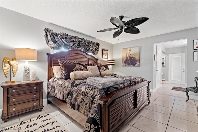 bedroom with ceiling fan, light tile patterned flooring, and a textured ceiling