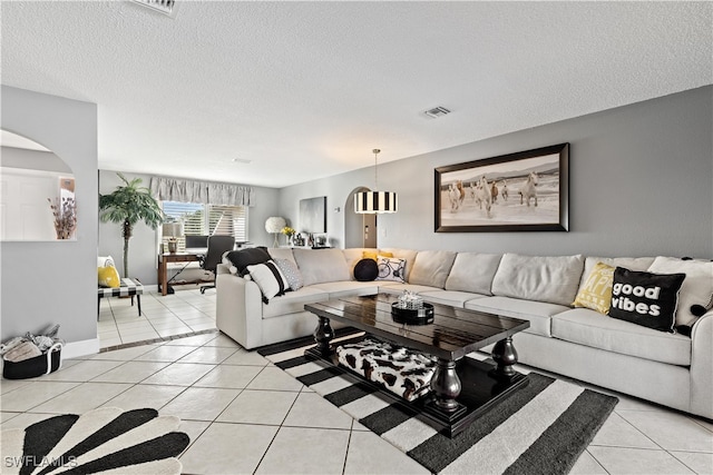 tiled living room featuring a textured ceiling