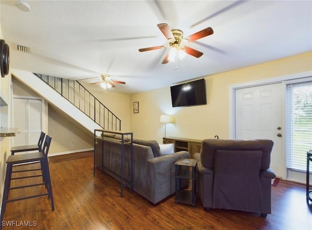 living room with ceiling fan and dark wood-type flooring