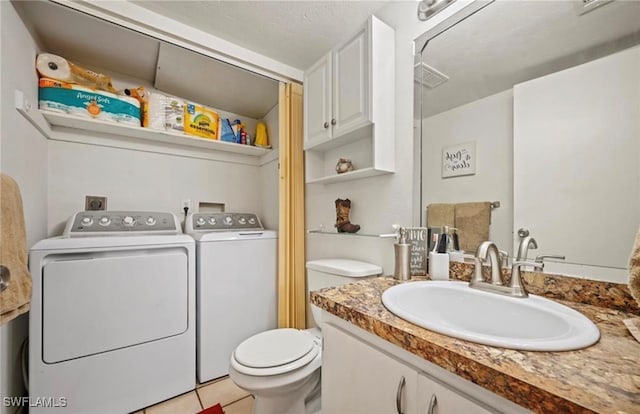 bathroom with tile patterned floors, a textured ceiling, vanity, washer and dryer, and toilet