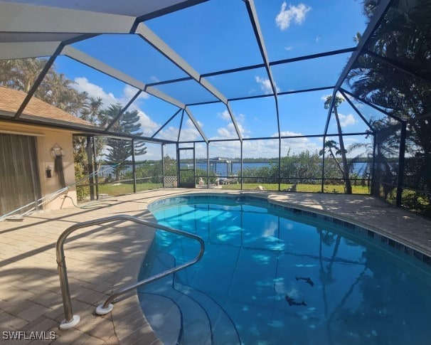 view of pool with glass enclosure and a patio area