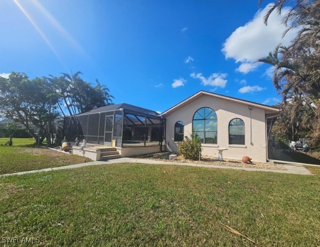 view of front facade with glass enclosure and a front lawn