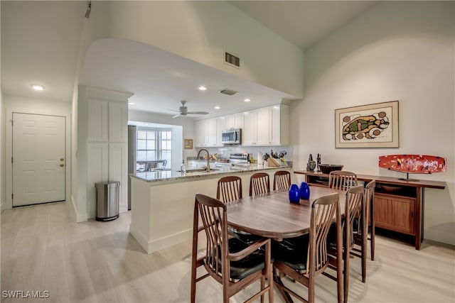 dining space featuring ceiling fan and light hardwood / wood-style flooring