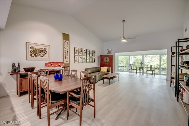 dining space featuring ceiling fan, high vaulted ceiling, and light hardwood / wood-style flooring