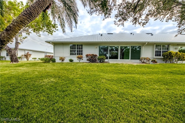 back of house with a lawn