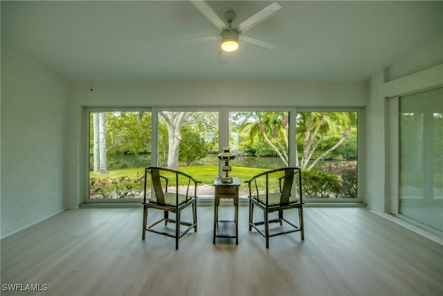 unfurnished sunroom with ceiling fan