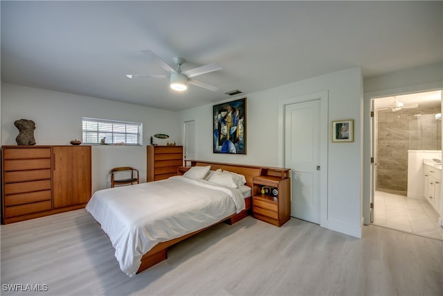 bedroom featuring connected bathroom, ceiling fan, and light wood-type flooring