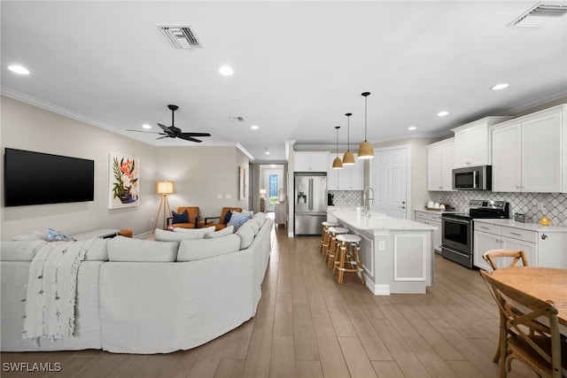 living room featuring sink, ceiling fan, light hardwood / wood-style flooring, and crown molding