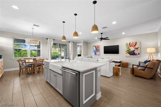 kitchen featuring pendant lighting, sink, a kitchen island with sink, ceiling fan, and stainless steel dishwasher