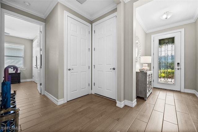 entrance foyer with ornamental molding and light hardwood / wood-style flooring