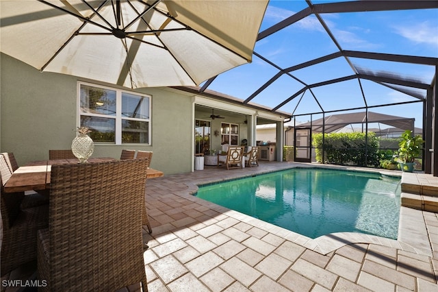 view of pool featuring ceiling fan, a patio, a lanai, and pool water feature