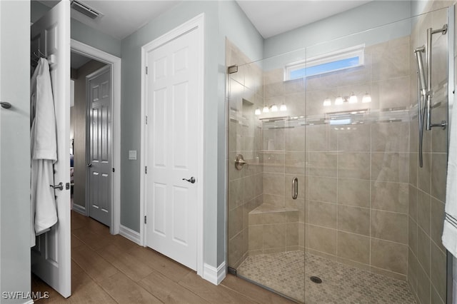 bathroom with wood-type flooring and a shower with door