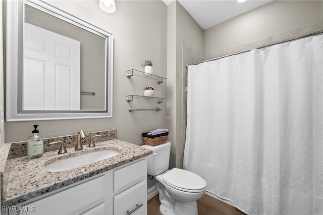 bathroom with hardwood / wood-style floors, toilet, and vanity