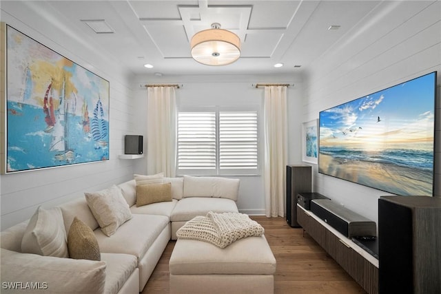 living room with light wood-style floors, wooden walls, and visible vents