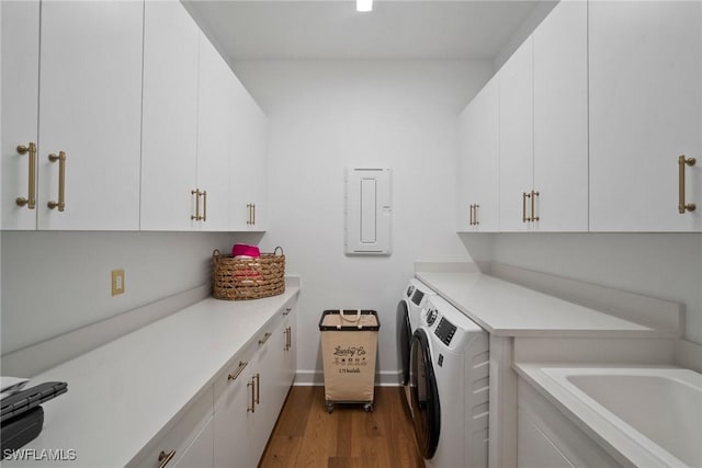 laundry room with cabinet space, washing machine and dryer, electric panel, and dark wood-style floors