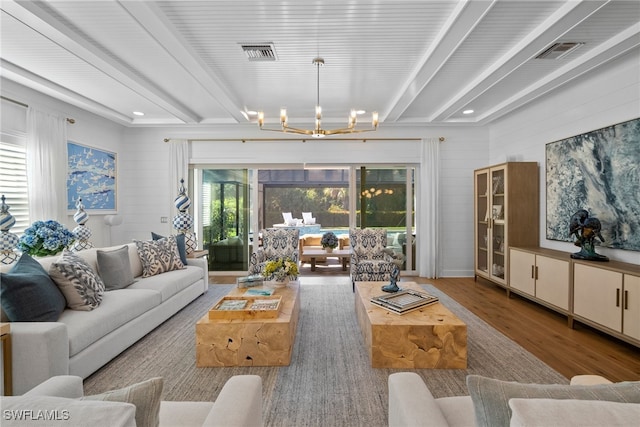 living room with hardwood / wood-style flooring, a notable chandelier, and beam ceiling