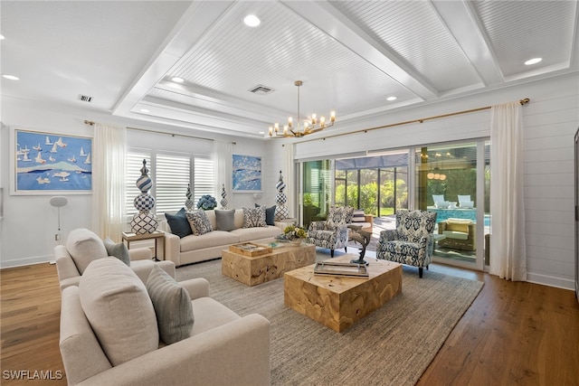 living room featuring beamed ceiling, light wood-type flooring, and a notable chandelier