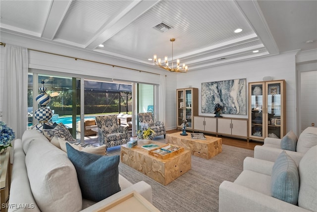 living room featuring beam ceiling, hardwood / wood-style floors, and a chandelier