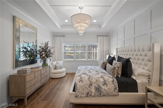 bedroom featuring a chandelier, hardwood / wood-style flooring, and a raised ceiling