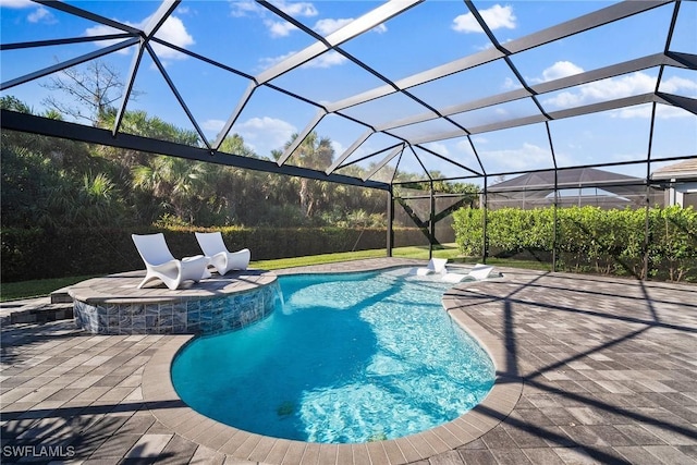 pool featuring glass enclosure and a patio