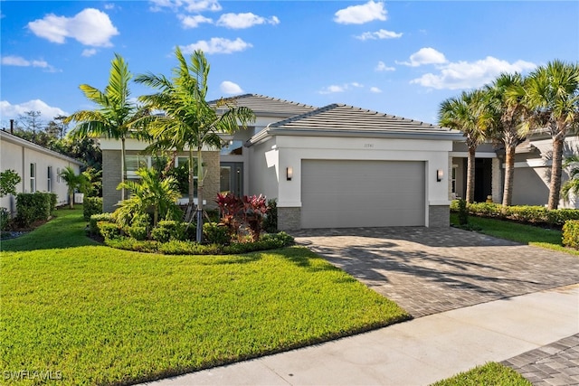 view of front of house featuring a garage, a front yard, decorative driveway, and stucco siding