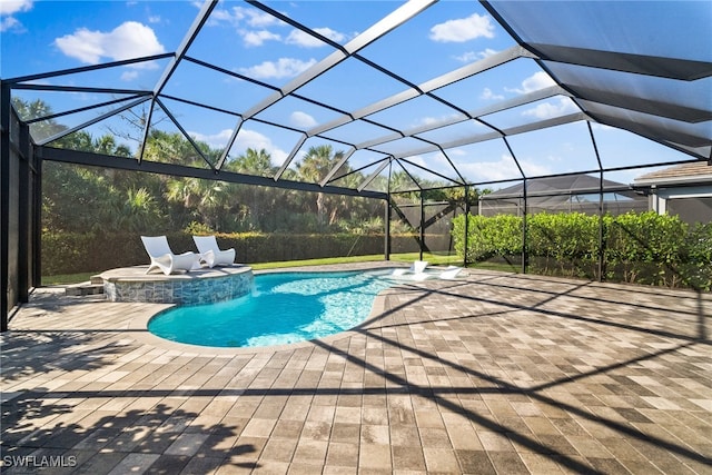 view of pool with a lanai, a patio area, and an in ground hot tub