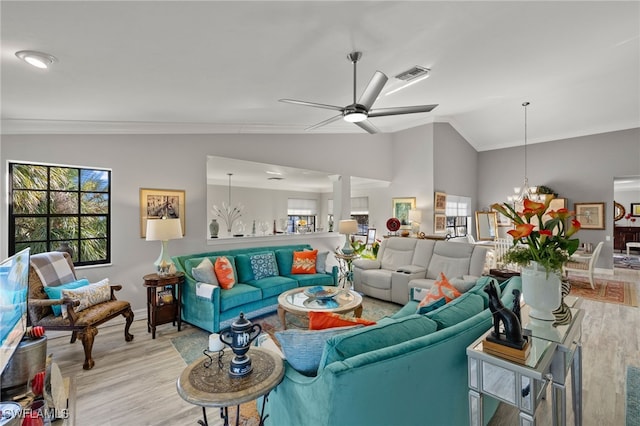 living room featuring light hardwood / wood-style floors, crown molding, and lofted ceiling