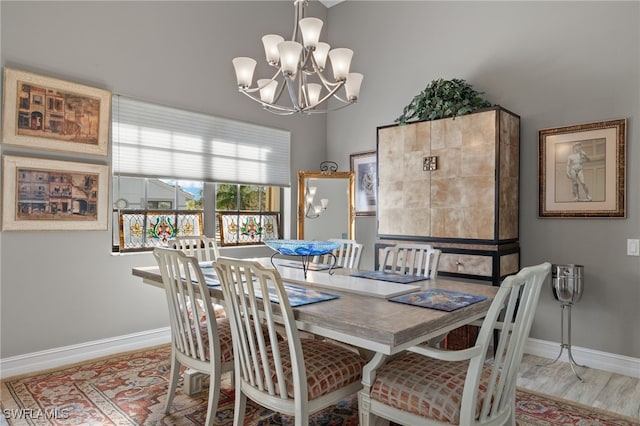 dining room with light hardwood / wood-style floors and an inviting chandelier