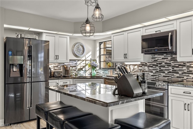 kitchen featuring decorative backsplash, a center island, stainless steel appliances, and a breakfast bar area