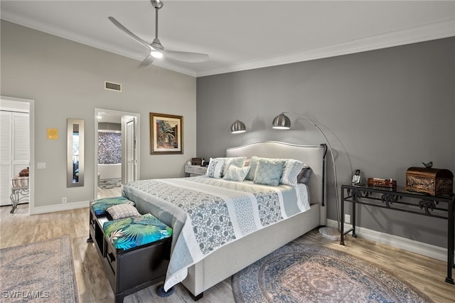 bedroom featuring hardwood / wood-style flooring, ceiling fan, crown molding, and connected bathroom