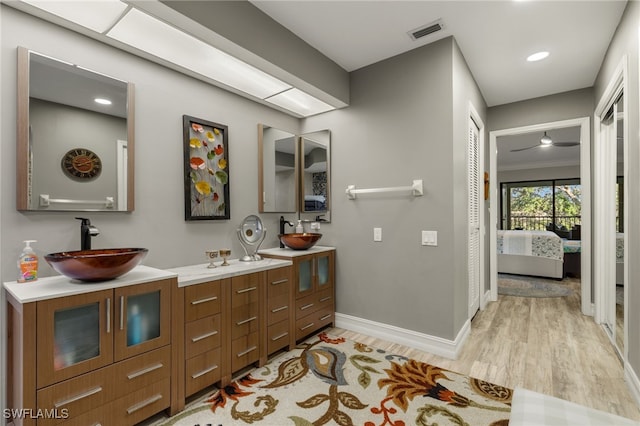 bathroom featuring ceiling fan, hardwood / wood-style floors, and vanity