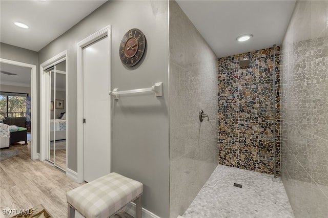 bathroom with hardwood / wood-style floors and tiled shower