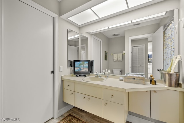 bathroom with vanity, toilet, and wood-type flooring