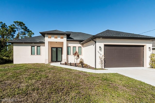 prairie-style home featuring a front lawn and a garage