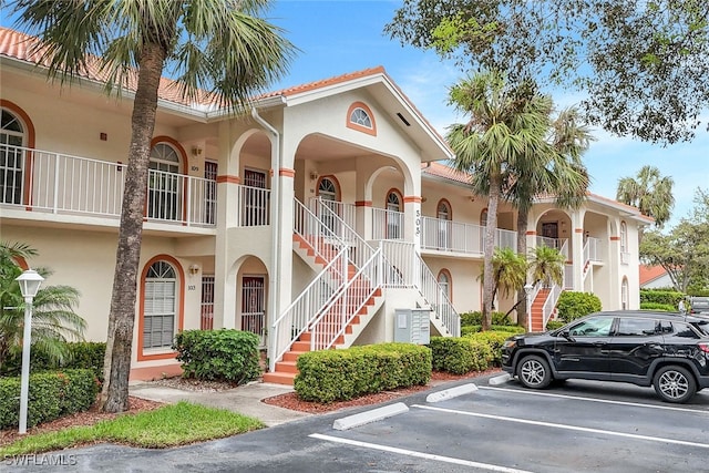 505 Mardel Dr Unit 112, Naples, FL 34104 - view of property with stairway and uncovered parking