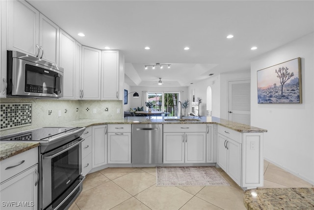 505 Mardel Dr Unit 112, Naples, FL 34104 - kitchen with appliances with stainless steel finishes, a sink, backsplash, light tile patterned floors, and light stone counters
