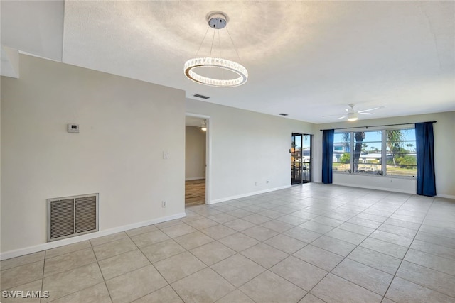 tiled empty room featuring ceiling fan