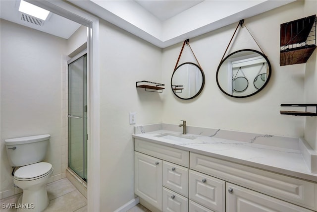 bathroom with tile patterned floors, vanity, toilet, and a shower with door