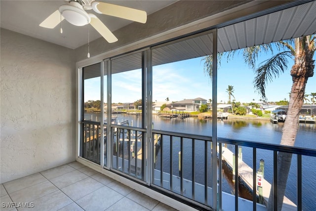 sunroom featuring a water view and ceiling fan