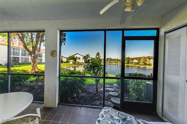 sunroom with a water view and ceiling fan