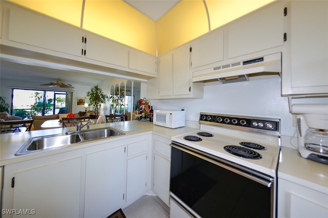 kitchen with kitchen peninsula, white appliances, ceiling fan, sink, and white cabinets