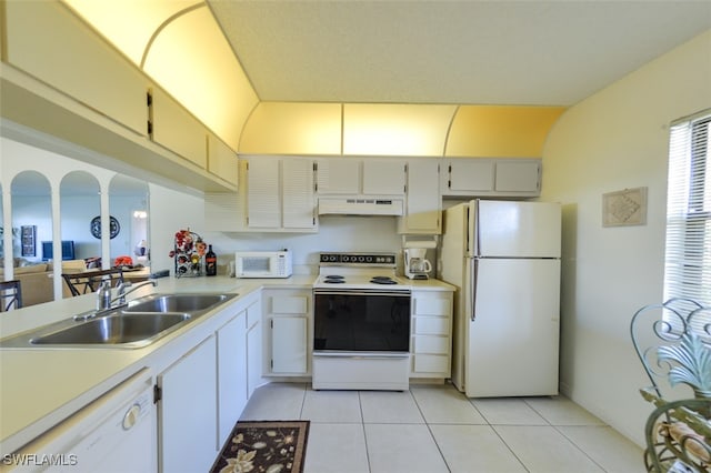 kitchen featuring sink, light tile patterned floors, and white appliances