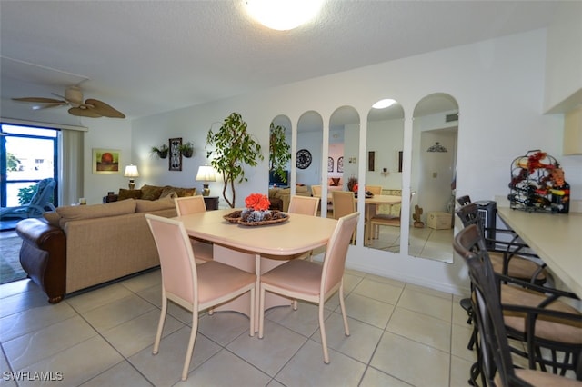 dining space with ceiling fan, light tile patterned floors, and a textured ceiling