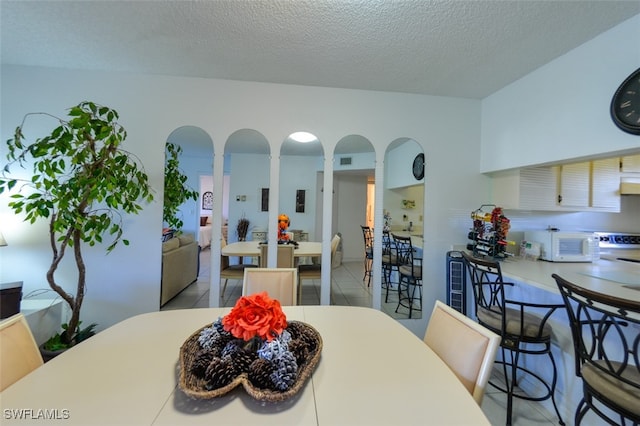 dining room with light tile patterned floors and a textured ceiling